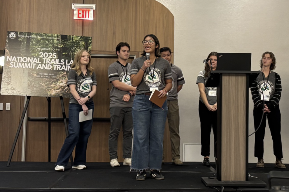 Apprentice holding a microphone on stage during a presentation