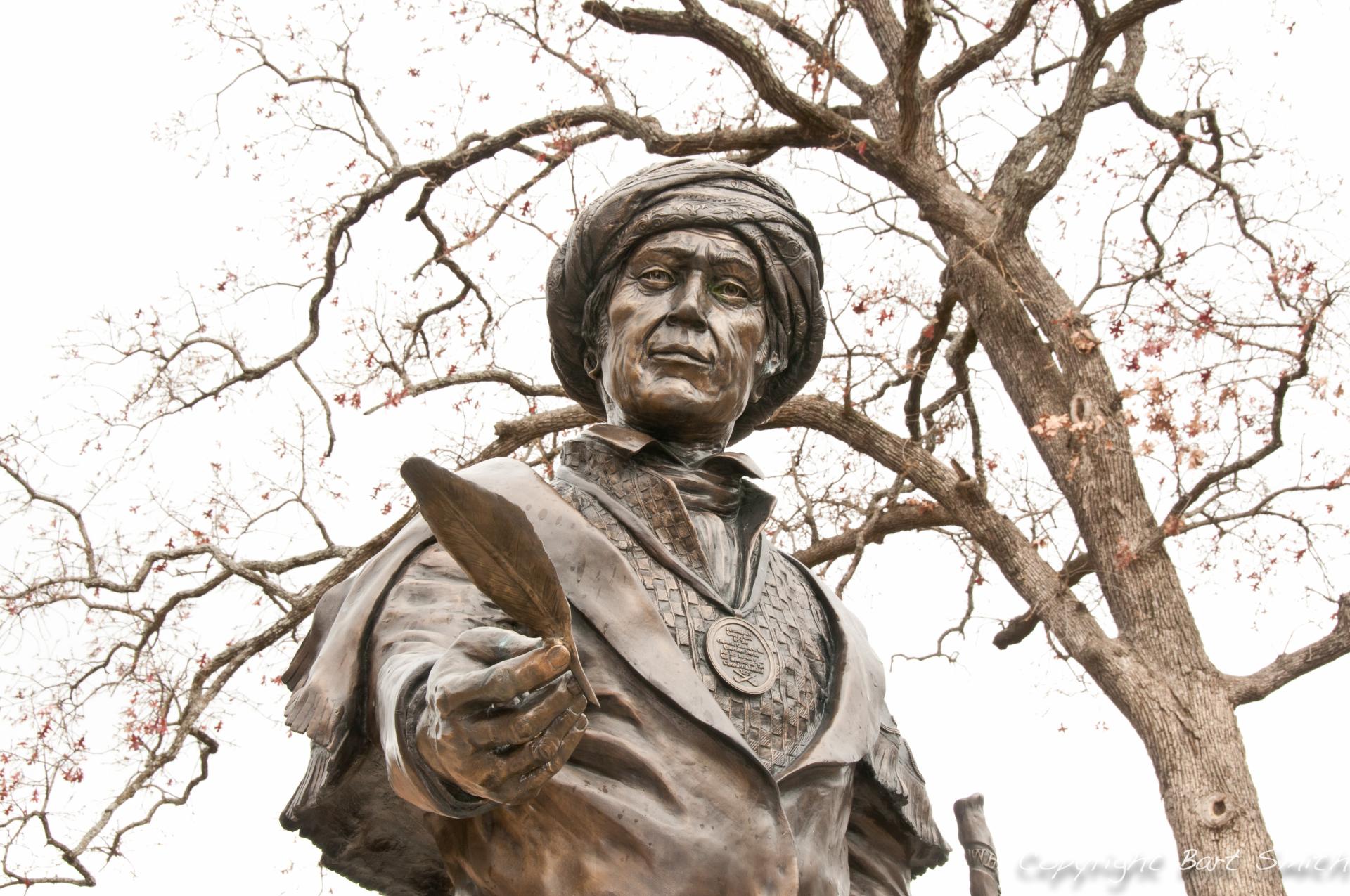 Statue of a man with a his hand outstretched holding a feather