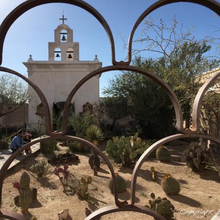 Gate framing a church in the desert
