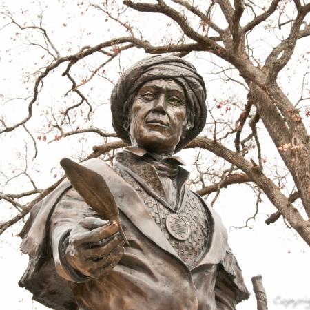 Statue of a man with a his hand outstretched holding a feather
